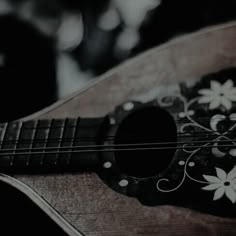 an acoustic guitar with white flowers on it