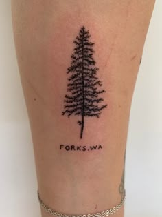 a small pine tree tattoo on the right side of the leg, which reads forks wa