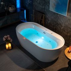 a bathtub with blue lights in the middle of a room next to a table