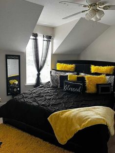 a bedroom with black and yellow bedding and pillows on the comforter is shown