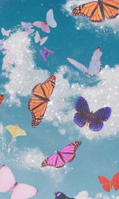 there are many different butterflies flying in the sky with white clouds and blue sky behind them