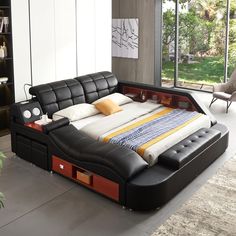 a large bed sitting in the middle of a room next to a book shelf and window