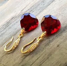 "Burgundy Garnet gold pave earrings. Heart cut garnets. Red stone jewelry. Red garnet dangles. Dark red garnet drops. Junuary birthstone. Available in 3 finishes. Length 1 1/4\". Dark red faceted gems are 14x14 mm as photo are sold, 19x14 mm and 13x17 mm stones are available. These beautiful earrings will arrive in a jewelry box ready for gift giving." Ruby Gemstone Earrings As Gift, Lab-created Ruby Gemstone Earrings As Gift, Lab-created Ruby Gemstone Earrings For Gift, Valentine's Day Drop Earrings Gift, Ruby Jewelry With Earrings For Valentine's Day, Red Heart-shaped Cubic Zirconia Earrings, Valentine's Day Ruby Jewelry With Matching Earrings, Red Garnet Earrings Gift, Red Garnet Earrings For Gifts