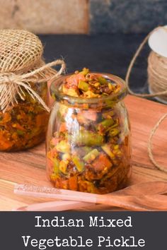 two jars filled with food sitting on top of a wooden cutting board