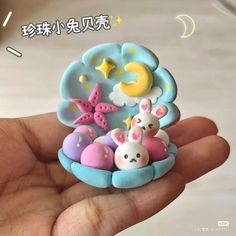 a hand holding a small toy in it's palm with the moon and stars on it