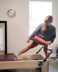 a woman is doing exercises on a rowing machine