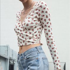 Brandy Melville Brandy Melville Floral Wrap Top White With Red Floral Super Cute Longsleeve Rose Wrap Top Nwot V-neck Floral Print Crop Top, Feminine Red V-neck Tops, Red Fitted Crop Top For Spring, Feminine Red Cotton Tops, Red Cotton Feminine Tops, Red V-neck Cotton Crop Top, Red V-neck Crop Top For Spring, Spring Red V-neck Crop Top, Red Fitted V-neck Crop Top