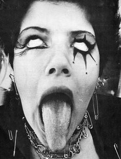 a woman sticking her tongue out with chains around her neck