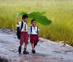 two young boys walking down a dirt road