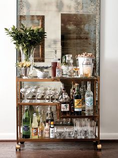 a bar cart filled with lots of bottles and glasses