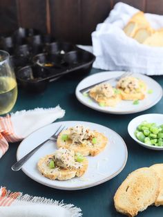 two plates with food on them next to some wine glasses and other foodstuffs