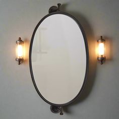 a bathroom mirror mounted to the wall with two lights on each side and one light on the other