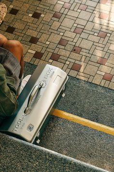 a person sitting on the ground next to an electronic device