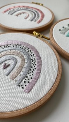 three embroidery hoops with different designs on them