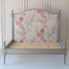 a bed frame with pink flowers and birds on it