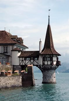 an old building with a tower next to the water