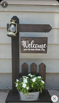 a potted plant sitting on top of a wooden stand next to a welcome sign