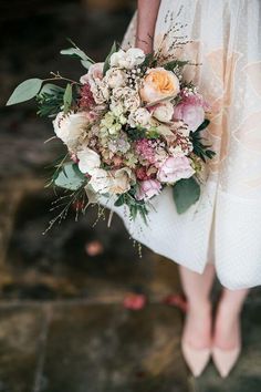 a bridal holding a bouquet of flowers and greenery