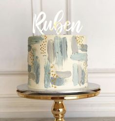 a white cake with blue and gold paint on it