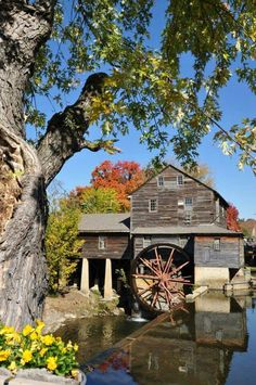 an old mill with water wheels in front of it