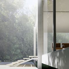 the interior of a modern house with trees in the back ground and stairs leading up to it