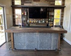 the bar is made out of wood and has bottles on it