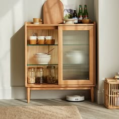 a wooden cabinet with glass doors and shelves filled with spices, condiments and other items