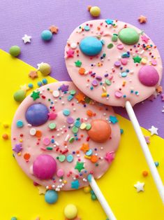 two donuts with sprinkles and candy on them