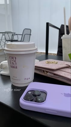 an iphone case sitting on top of a table next to a cup of coffee