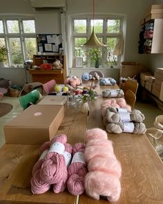 several skeins of yarn sitting on top of a wooden table in a room