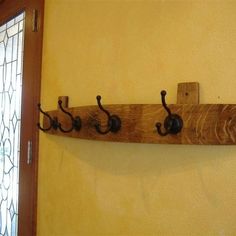 a coat rack made out of wood and metal hooks