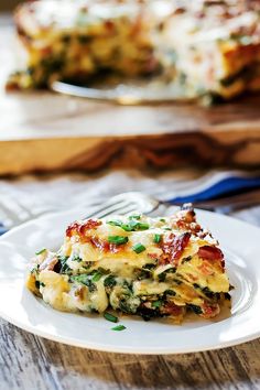 a slice of lasagna on a white plate next to a blue and silver fork