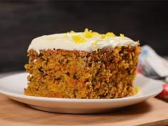 a piece of carrot cake sitting on top of a black plate