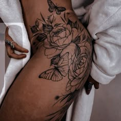 a woman's thigh with flowers and butterflies on it