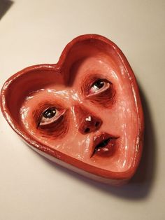 a heart shaped object with two eyes and one eye opened to show the same person's face