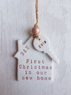 a white ceramic ornament with a house and key hanging from it's side