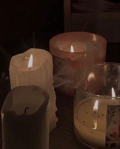 three lit candles sitting next to each other on a table