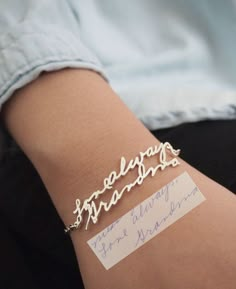 a woman's arm with a name bracelet on it