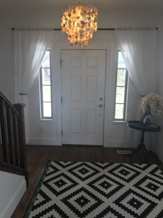 a white door with two windows and a black and white rug in front of it