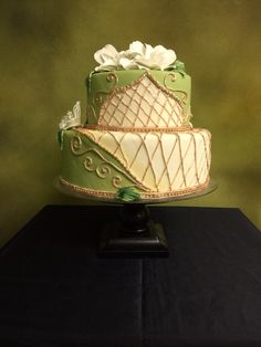 a green and white cake sitting on top of a black table next to a wall