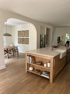 a kitchen with an island in the middle of it and lots of wood flooring