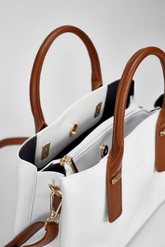 The Porcelain White Hudson Tote is sleek and stylish with a classic brown strap. Crafted with a luxurious Porcelain white leather, its timeless design is ideal for any occasion. It provides the flexibility to be worn as a tote or crossbody bag. Material: Genuine Soft Vegan Leather Dimensions : 33 L x 14 w x 23 h Pockets: 6 Interior compartments Straps : 2 chocolate brown handles & 1 chocolate brown crossbody strap Locks: 2 snap gold locks & Middle zipper Color : Porcelain White Business Shoulder Bag, Chic White Shoulder Bag For Business, White Double Handle Shoulder Bag For Business, Timeless White Satchel Shoulder Bag, White Bags With Adjustable Handle For Everyday Use, White Tote Shoulder Bag For Business, White Top Handle Shoulder Bag With Handle Drop, White Business Bag With Detachable Strap, White Business Bag With Adjustable Strap