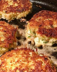 four crab cakes cooking in a skillet