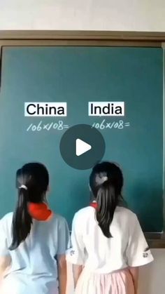 two girls standing in front of a chalkboard with china and india written on it