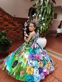 a woman in a colorful dress made out of paper flowers