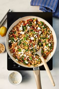 a pan filled with food sitting on top of a stove next to an oven mitt