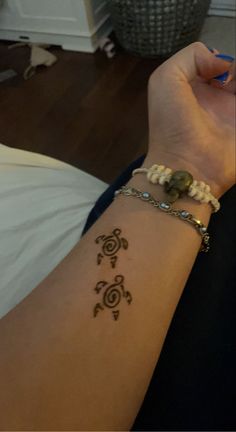 a woman's arm with a tattoo on it and a bracelet around her wrist