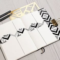 an open notebook with some black and white designs on it next to a pair of scissors