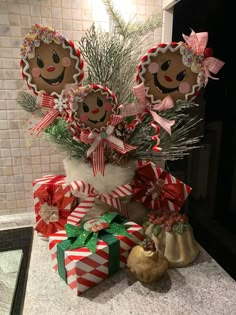 some gingerbread men are sitting on top of christmas presents and decorations in a kitchen