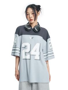 It is a short sleeves football jersey that is made of moisture-wicking and breathable fabric. The t-shirt has colorblock design and graphic print on the sleeves and front. The balloon oversized fit t-shirt makes casual and stylish outfit.- Balloon oversized fit- Stripes on sleeves- Graphic print- Stripe point on neck Athleisure Jersey T-shirt With Letter Print, Sporty T-shirt With Graphic Print For Sports Events, Sporty Oversized T-shirt For Game Day, Sporty Short Sleeve T-shirt For Sports Season, Sporty White T-shirt With Number Print, White Short Sleeve Jersey For Streetwear, Short Sleeve Jersey For Sports Season Streetwear, Streetwear Jersey For Sports Season With Short Sleeves, Short Sleeve Sports T-shirt With Contrast Color